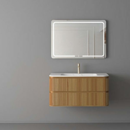 Contemporary wall-mounted vanity with a ribbed acacia wood finish, a white Carrara porcelain basin, and soft-closing drawers. Paired with a rectangular LED mirror, creating a sleek and modern aesthetic against a gray wall.
Elegant acacia wood vanity featuring a Carrara porcelain countertop, soft-closing drawers, and a rectangular LED mirror with versatile functionalities. Designed for modern interiors with a focus on style and practicality.