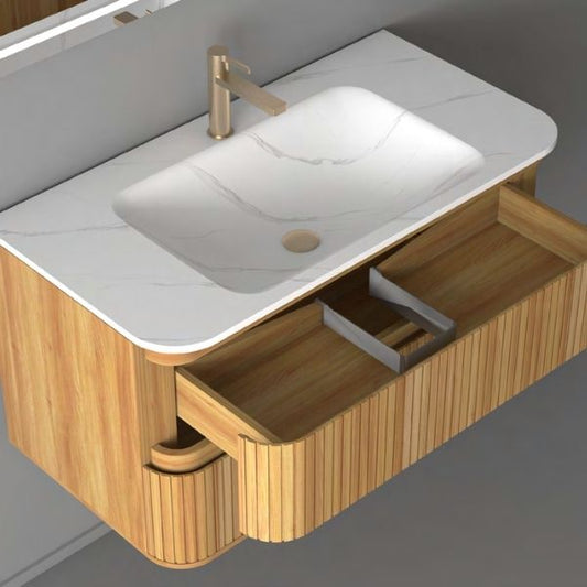 Contemporary wall-mounted vanity with a ribbed acacia wood finish, a white Carrara porcelain basin, and soft-closing drawers. Paired with a rectangular LED mirror, creating a sleek and modern aesthetic against a gray wall.
Elegant acacia wood vanity featuring a Carrara porcelain countertop, soft-closing drawers, and a rectangular LED mirror with versatile functionalities. Designed for modern interiors with a focus on style and practicality.