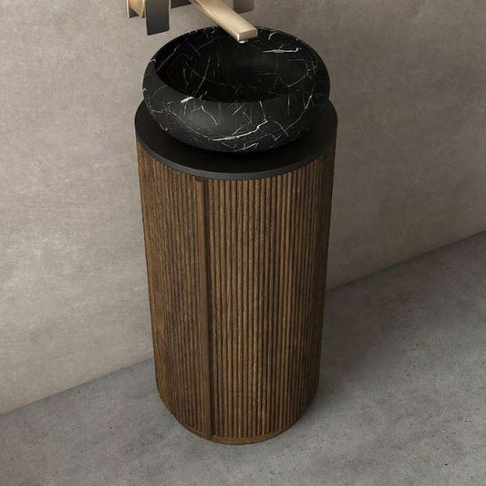 Elegant freestanding vanity featuring a ribbed black walnut wood cabinet with a round black porcelain basin, paired with an oval LED mirror. Complemented by a soft pink pendant light, creating a modern yet sophisticated look.
Compact freestanding vanity with a black walnut lacquered cabinet, black porcelain countertop, and above-counter round ceramic basin. Includes an oval LED mirror and hidden storage with soft-closing hinges for a sleek and functional design.