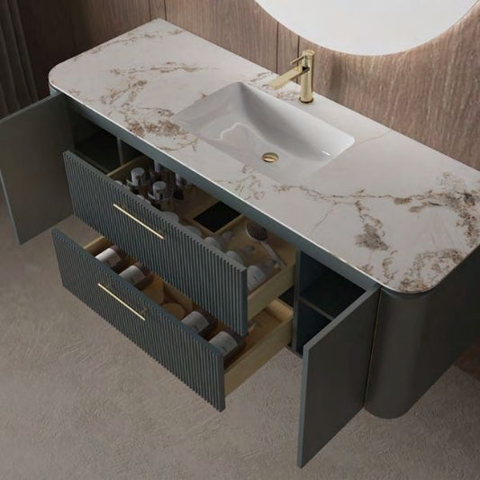 Modern vanity set featuring a sintered stone countertop, emerald gray lacquered finish, and two soft-closing drawers with gold handles. Includes a ceramic undermount sink and LED mirror with multiple functionalities.
Elegant bathroom vanity with an emerald gray lacquered finish, gold accents, and a sintered stone countertop, set against a warm wooden wall