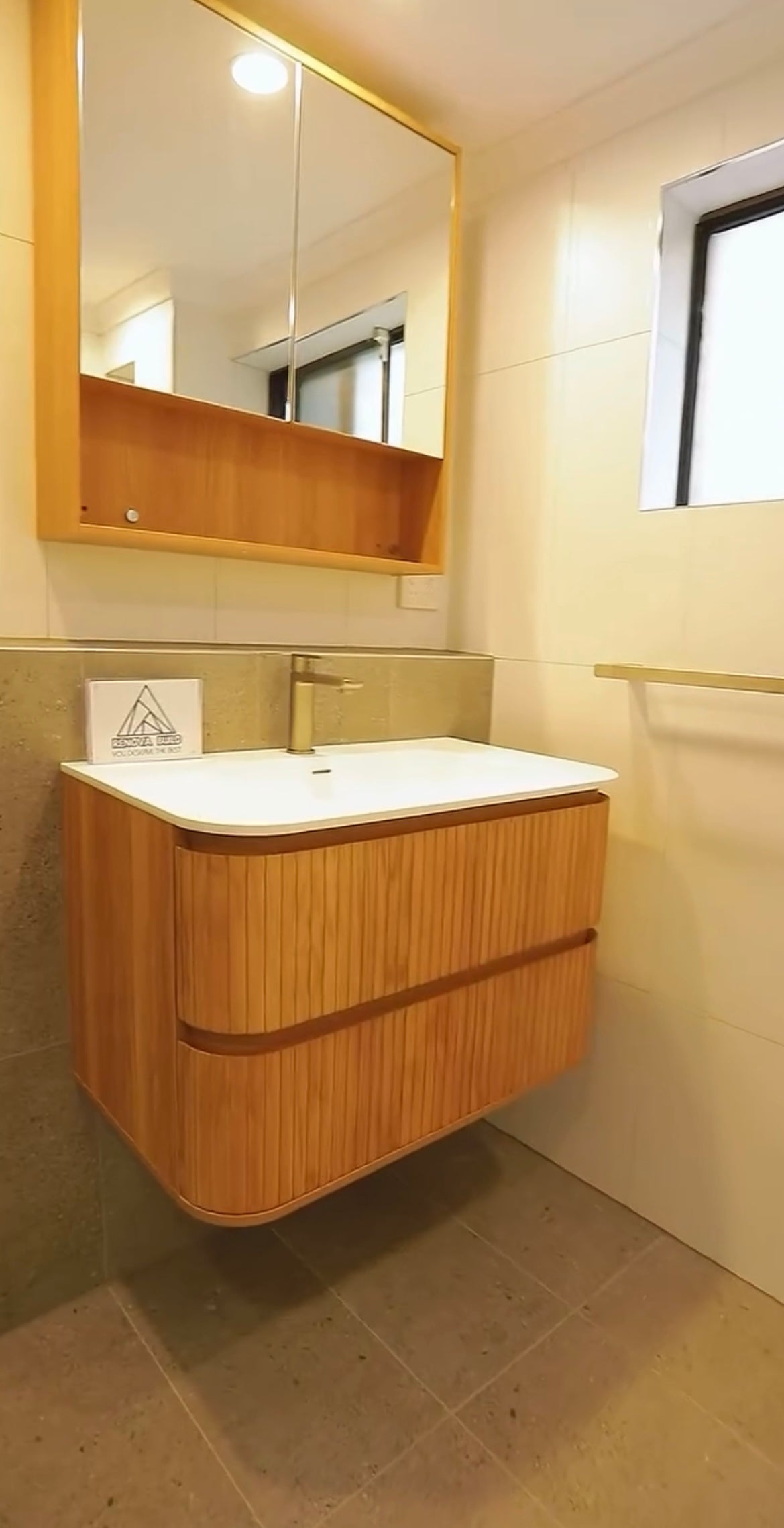 Completed bathroom renovation featuring custom timber vanity and mirrored cabinet — Renova Build project